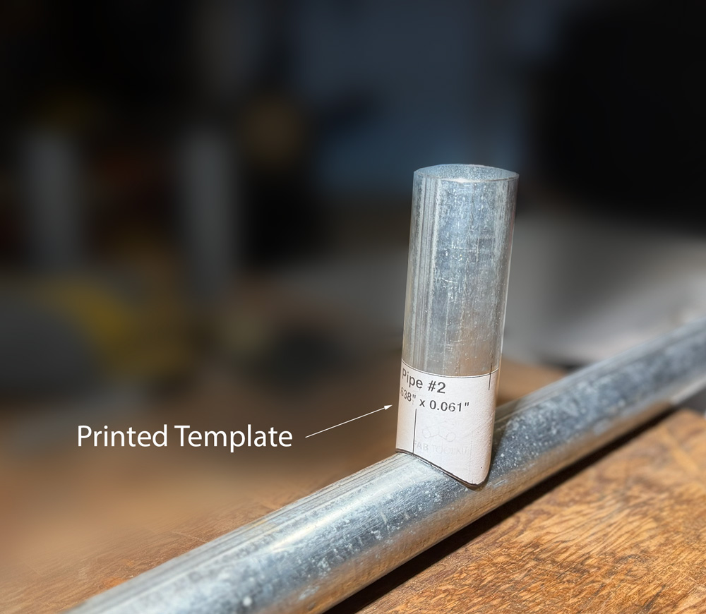A photo of a saddle joint template wrapping around a tube, showing how the projection lines match the tube's curvature.
